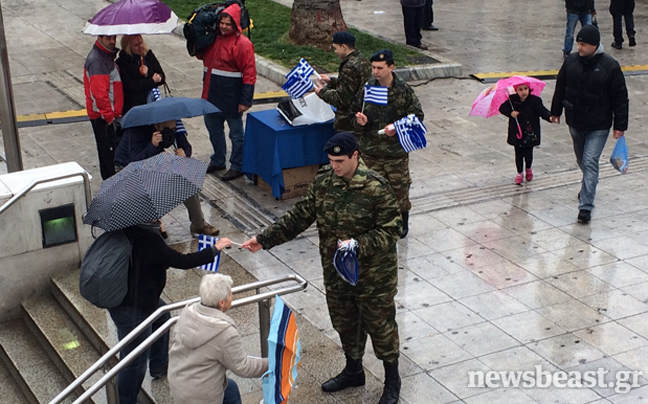Στρατιώτες μοιράζουν πλαστικά σημαιάκια στο Σύνταγμα