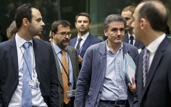 Greek Finance Minister Euclid Tsakalotos, third right, arrives for a round table meeting of eurozone finance ministers at the EU LEX building in Brussels on Tuesday, July 7, 2015. Greek Prime Minister Alexis Tsipras was heading Tuesday to Brussels for an emergency meeting of eurozone leaders, where he will try to use a resounding referendum victory to eke out concessions from European creditors over a bailout for the crisis-ridden country. (AP Photo/Michel Euler)