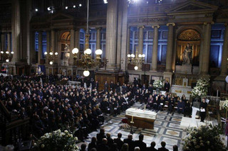 Family members, officials and other mourners attend the funeral service of French rocker Johnny Hallyday at the Madeleine church, in Paris, France, Saturday, Dec. 9, 2017. France is bidding farewell to its biggest rock star, honoring Johnny Hallyday with an exceptional funeral procession down the Champs-Elysees, a presidential speech and a motorcycle parade — all under intense security. (AP Photo/Thibault Camus, Pool)