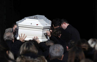 The coffin of French rock singer Johnny Hallyday is carried into La Madeleine church Saturday Dec. 9, 2017 in Paris. France is bidding farewell to its biggest rock star, honoring Johnny Hallyday with an exceptional funeral procession down the Champs-Elysees, a presidential speech and a parade of motorcyclists — all under intense security. (Yoan Vallat, Pool via AP)