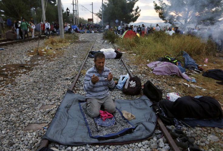 A Syrian refugee prays on a rail track at the Greek-Macedonian border, near the village of Idomeni, August 22, 2015. Crowds of migrants and refugees were building on Greece's border with Macedonia on Saturday after a cold, wet night spent in the open, their entry slowly rationed by Macedonian police and soldiers. REUTERS/Yannis Behrakis TPX IMAGES OF THE DAY A Syrian refugee prays on a rail track at the Greek-Macedonian border, near the village of Idomeni, August 22, 2015. Crowds of migrants and refugees were building on Greece's border with Macedonia on Saturday after a cold, wet night spent in the open, their entry slowly rationed by Macedonian police and soldiers. REUTERS/Yannis Behrakis TPX IMAGES OF THE DAY
