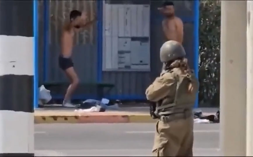 Η στιγμή που Ισραηλινή στρατιώτης στρέφει το όπλο σε δύο μέλη της Χαμάς και τους αναγκάζει να βγάλουν τα ρούχα τους