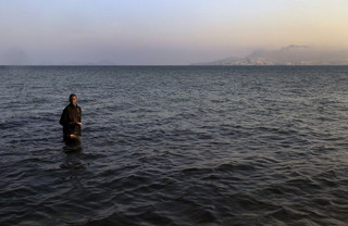 A migrant from Mali walks ashore on the Greek island of Kos after he and seven others paddled across a part of the Aegean Sea between Turkey and Greece on, August 8, 2015. The U.N refugee agency, UNHCR, estimates that Greece has received more than 107,000 refugees and migrants this year, more than double its 43,500 intake of 2014. REUTERS/ Yannis Behrakis