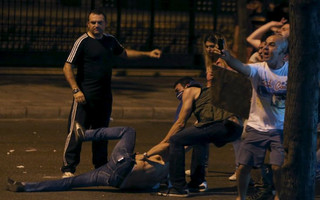 Lebanese protesters help a wounded man during a protest against corruption and rubbish collection problems near the government palace in Beirut