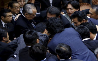 Lawmakers crowd around Konoike, chairman of the upper house special committee on security, during a vote at an upper house special committee session on security-related legislation at the parliament in Tokyo