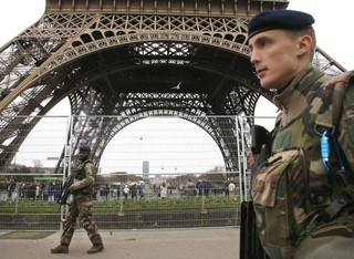 French soldiers patrol in front of the Eiffel Tower in Paris, France, Sunday, Dec. 24, 2017. France's government is deploying nearly 100,000 police and soldiers for the holiday season as fears of extremist attacks remain high. (AP Photo/Michel Euler)