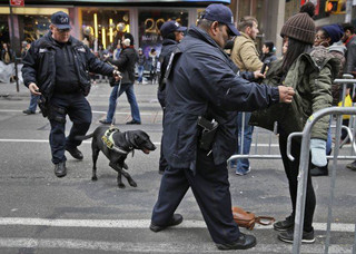 FILE - In this Dec. 31, 2015 file photo, pedestrians submit to a search as they enter Times Square in New York. New York Police Department officials say that while there are no specific or credible threats against the city, they are promising a bigger security detail than ever before at the Sunday, Dec. 31, 2017, New Year's Eve celebration in Times Square. (AP Photo/Seth Wenig, File)