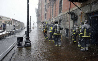 Boston firefighters work at the scene of flooding from Boston Harbor on Long Wharf in Boston, Thursday, Jan. 4, 2018. A massive winter storm swept from the Carolinas to Maine on Thursday, dumping snow along the coast and bringing strong winds that will usher in possible record-breaking cold. (AP Photo/Michael Dwyer)