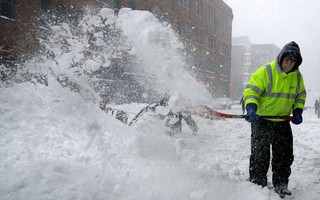 Workers clear snow from a sidewalk in the Seaport District of Boston, Thursday, Jan. 4, 2018. Forecasts for the Boston area call for about a foot of snow during the day and blizzard-like conditions.(AP Photo/Charles Krupa)