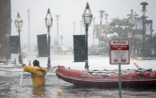 A Boston firefighter wades through flood waters from Boston Harbor on Long Wharf in Boston, Thursday, Jan. 4, 2018. A massive winter storm swept from the Carolinas to Maine on Thursday, dumping snow along the coast and bringing strong winds that will usher in possible record-breaking cold. (AP Photo/Michael Dwyer)