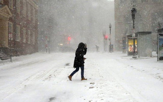 A pedestrian crosses the street in downtown Boston, Thursday, Jan. 4, 2018. A massive winter storm swept from the Carolinas to Maine on Thursday, dumping snow along the coast and bringing strong winds that will usher in possible record-breaking cold. (AP Photo/Michael Dwyer)