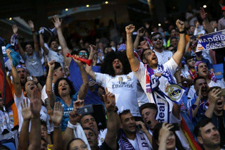 Real Madrid supporters watch on big screens placed in the team's Santiago Bernabeu stadium, as the team play in the Champions League final match between Real Madrid and Liverpool being played in Kiev, Ukraine, in Madrid, Saturday, May 26, 2018. (AP Photo/Francisco Seco)