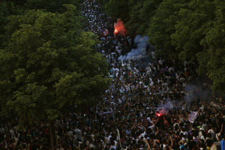 Real Madrid supporters light flares as they cheer outside the team's Santiago Bernabeu stadium prior to the Champions League final match between Real Madrid and Liverpool being played in Kiev, Ukraine, in Madrid, Saturday, May 26, 2018. (AP Photo/Francisco Seco)