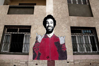 This May 2, 2018 photo, shows a wall mural of Mohamed Salah at a sports and youth center, in the Nile delta village of Nagrig, Egypt. Residents boast of how the Liverpool winger has poured millions of pounds into the village, with the beneficiaries’ list including a school, a mosque, a youth center and a dialysis machine at a nearby hospital. His success as a footballer in Europe’s most attractive league has inspired many parents in Nagrig to send their children to soccer academies in the hope that maybe one day they can emulate his success. (AP Photo/Nariman El-Mofty)