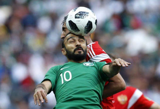 Saudi Arabia's Mohammed Alsahlawi, foreground, jumps for the ball with Russia's Alexander Samedov during the group A match between Russia and Saudi Arabia which opens the 2018 soccer World Cup at the Luzhniki stadium in Moscow, Russia, Thursday, June 14, 2018. (AP Photo/Hassan Ammar)