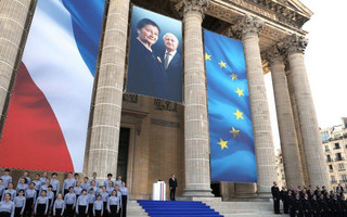 French President Emmanuel Macron, rear, stands on the steps of the Pantheon in tribute to late Holocaust survivor Simone Veil and her late husband Antoine Veil during a national tribute before being laid to rest in the crypt of the Pantheon mausoleum, in Paris, France, Sunday, July 1, 2018. Simone Veil, who became one of France's most revered politicians, is getting the rare honor of being buried with her husband Antoine, who died in 2013, at the Pantheon, where French heroes are interred, one year after her death. (Ludovic Marin/Pool Photo via AP)