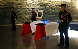 The flag-draped coffins of French politician Simone Veil, right, and her husband Antoine Veil are displayed at  the French Holocaust memorial in Paris, Friday, June 29, 2018. A year after the death of Simone Veil, the guarded casket of the Holocaust survivor who became one of France's most revered politicians, lies at the Holocaust Memorial in Paris, along with that of husband Antoine, so the public can pay homage ahead of the couple's burial on Sunday at the Pantheon, where French heroes are interred. (AP Photo/Thibault Camus)