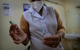 Νοσηλεύτρια που κρατά εμβόλιο στη Μεγάλη Βρετανία